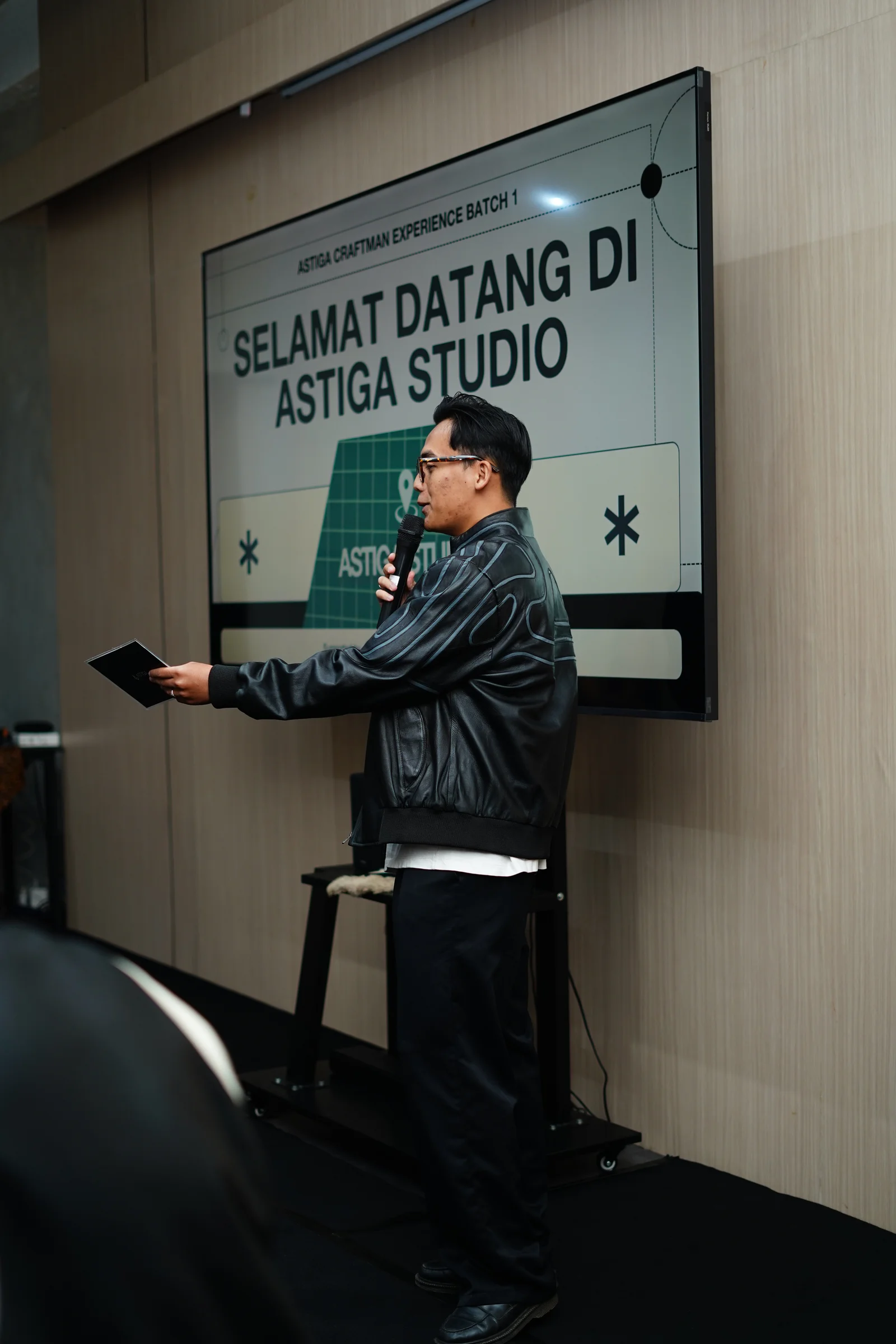 MC Syahril membuka acara Astiga Craftsman di samping layar sambutan