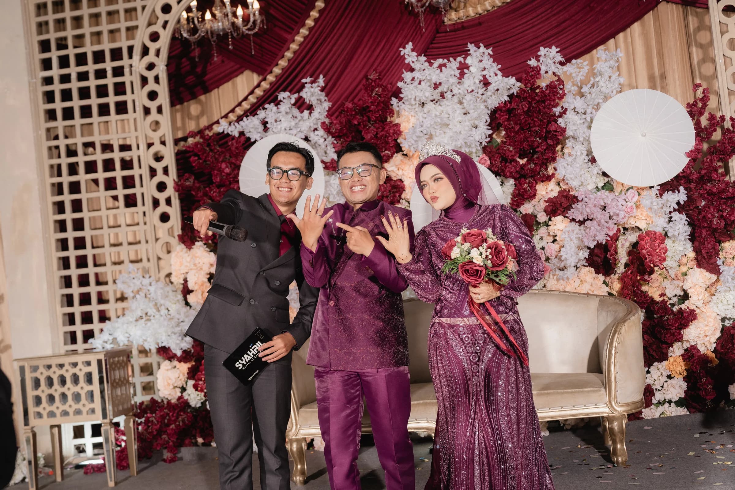MC Syahril berfoto bersama kedua mempelai memamerkan cincin nikah